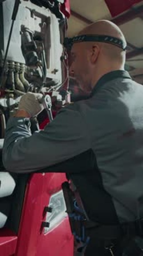 Vertical of Male Mechanic Repairing Truck Hood in Car Service