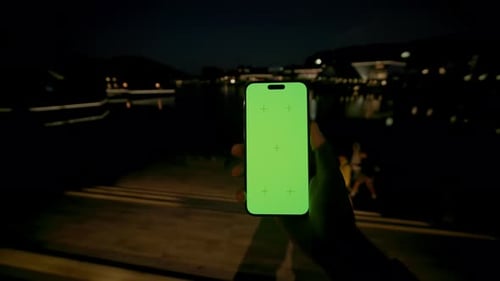 Horizontale Nahaufnahme eines männlichen kaukasischen Mannes, der ein Smartphone mit grünem Bildschirm in der Hand hält