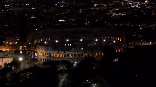 Ancient Colosseum Amphitheatre. Downtown Rome, Italy. Close Up Aerial View Night