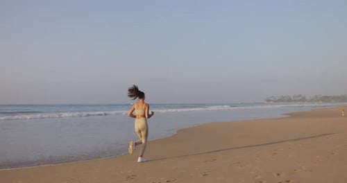 Female Runner Jogging During Outdoor Workout on the Beach in Slow Motion