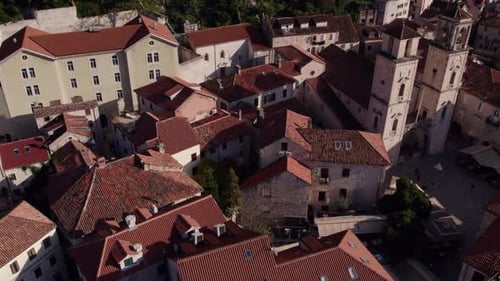 Aerial view of medieval town with church, harbor, and mountain, Montenegro.