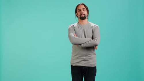 Man Smiles Confidently with Arms Crossed Studio Shot