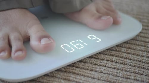 Person Weighs Themselves on a Bathroom Scale