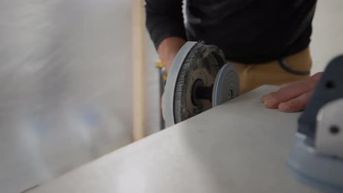 Man using machine to cut sheet of material