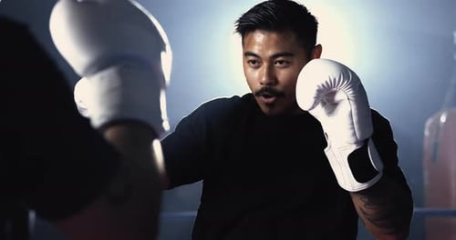 Gloved Combatant Awaits Duel, Steely Gaze on Rival, Dramatically Illuminated in Boxing Ring