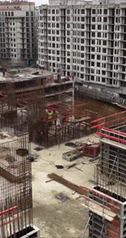 Cinematic Vertical Drone Approach to Construction Workers Installing Reinforcement Bars at Residenti