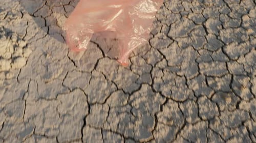 Una bolsa de plástico vuela en tierra seca: desastre ambiental