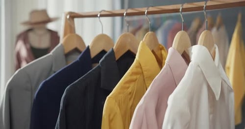 Close-up clothes hang on clothes rack in clothing store with sweet tone.