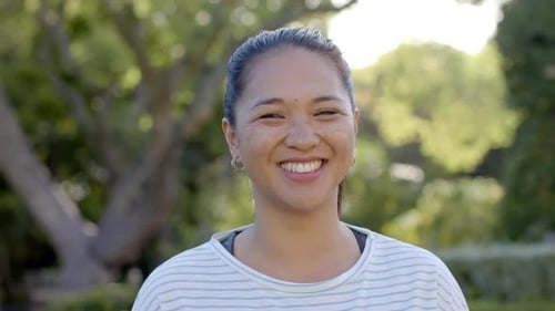 Smiling woman outdoors in park, enjoying sunny day and nature