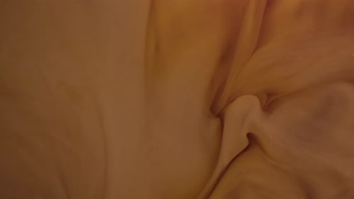 Milk pouring into coffee slow motion.