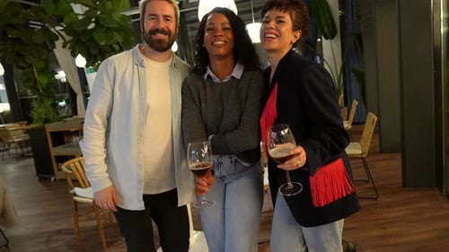 Three Friends Posing with Drinks in Restaurant