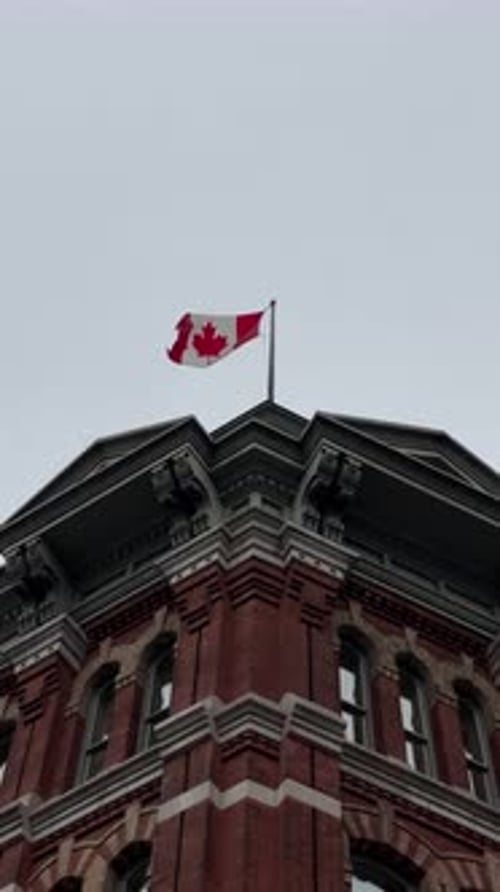 Canada Flag Waving atop Historic Building