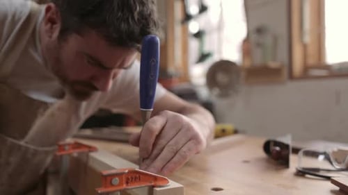 Carpenter Using Mallet and Chisel on Wood in Workshop 3539 Years