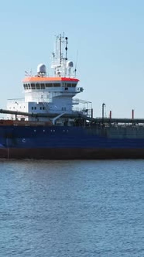 Suction Dredger Ship Entering Industrial Port on Sunny Day