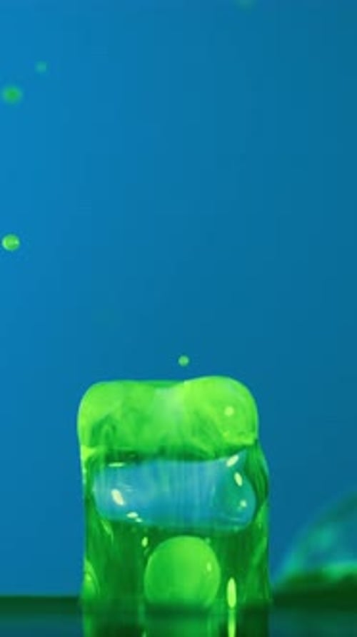 Green Water Splashing In Slow Motion Against Blue Background
