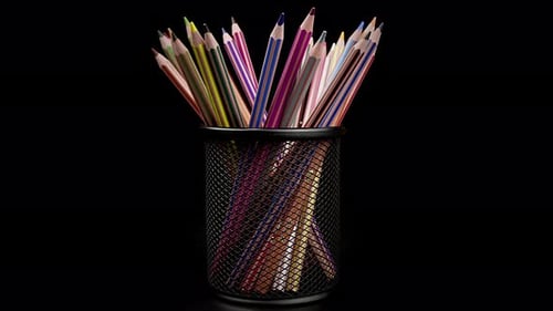 Colorful Pencils in Wire Mesh Container on Black