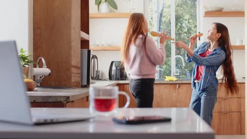 Women Singing and Dancing Together in a Kitchen