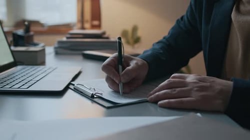 Bearded Man Taking Notes at Office Desk