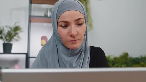 Muslim Businesswoman Freelancer at Office Workplace Working on Laptop Computer Sends Online Messages