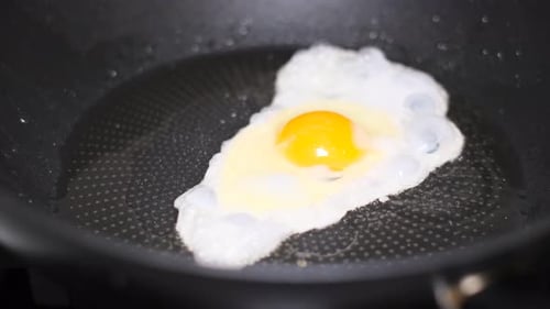Spiegelei in einer Pfanne in Sonnenblumenöl, Nahaufnahme