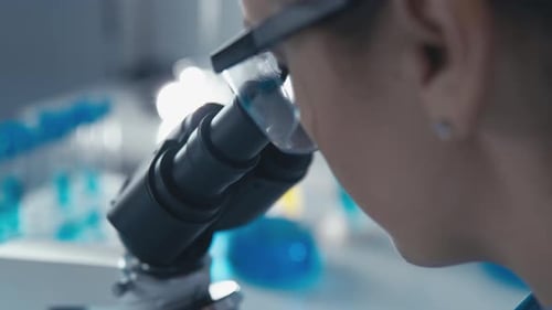 Ein fokussierter Forscher beobachtet sorgfältig verschiedene biologische Proben unter dem Mikroskop in einem