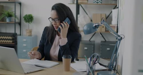 Business Lady Making Mobile Phone Call Typing with Computer Talking and Writing in Office