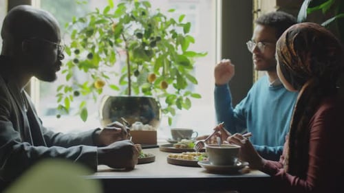 Multiethnic Colleagues Talking over Lunch in Cafe