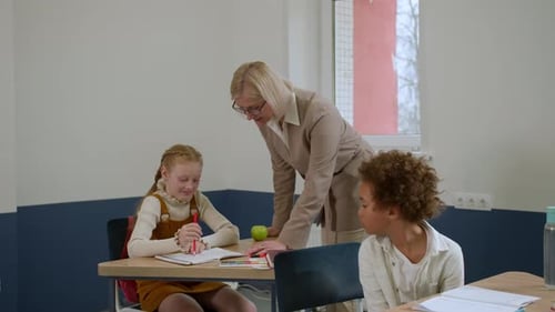 Elementary School Class Children Communicate with the Teacher Answering Question