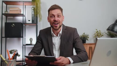 Business Man at Home Office Analysing Paperwork Documents Shocked By Sudden Victory Good News Wow