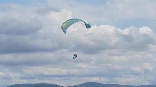 Person Paragliding Over Forested Mountain With White CLouds In Background - Rosins Lookout In Scenic