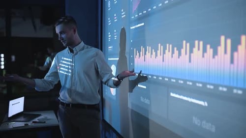 Man Presenting Data on Interactive Display in Office
