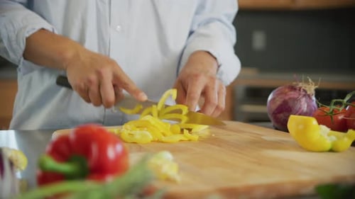Close Up Shot Of Man Cutting Yellow Bell Pepper