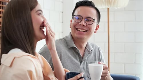 Couple Smiling and Drinking Coffee at Home
