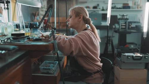 Focused Female Jeweler Crafting Handmade Jewelry in Workshop