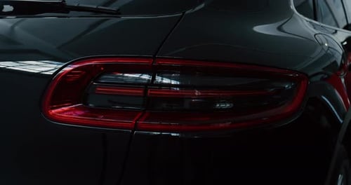 Close up of details of switched on tail lights of anonymous prestigious luxury modern car. Shot in