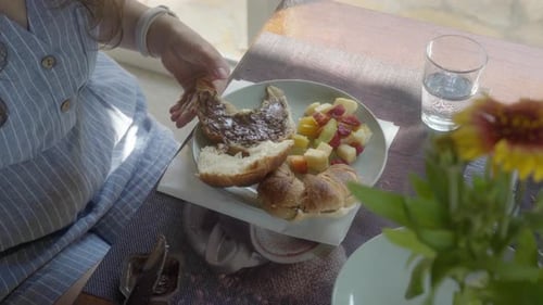 Young Adult Spreads Chocolate on Bun for Breakfast