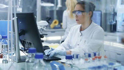 Medical Research Scientist Typing Information Obtained from New Experimental Drug Trial. She Works
