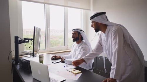 Two Men Work Together at Computer in Office