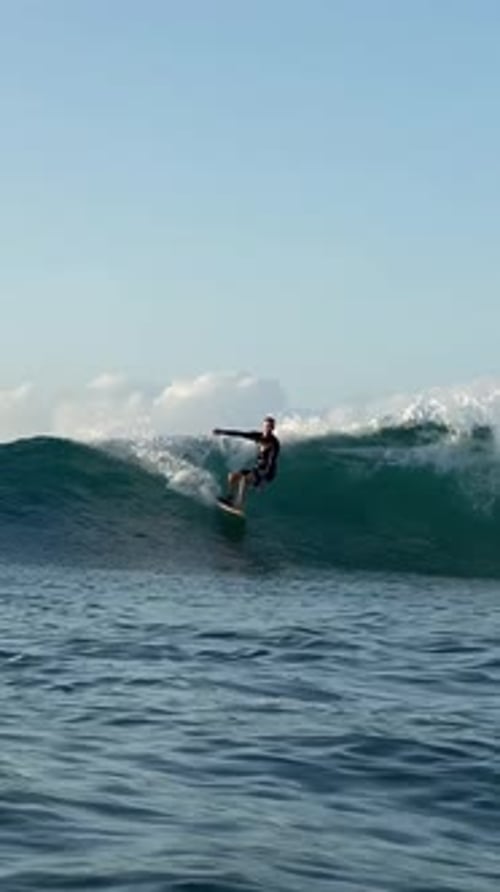 Young Man Surfs in the Ocean