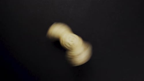 Peanuts in shells, rotates. Falls onto the table. Close-up. Black background. View from above.