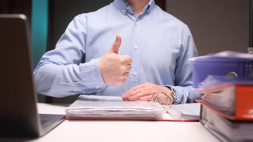 Businessman Gesturing Thumbs Up Approving Successful Work in Office