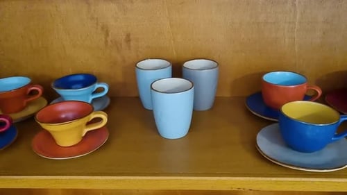 Handmade ceramic tableware with a set of colorful clay cups and plates