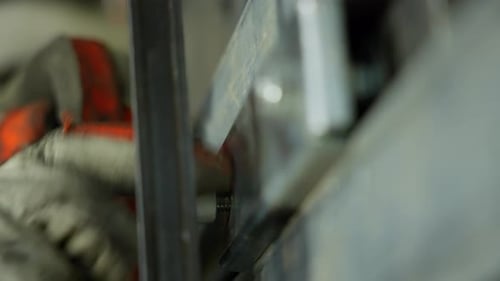 Tightening bolt with gloved hand, industrial hardware