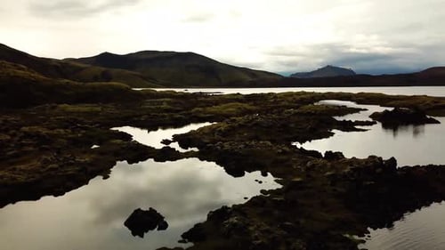 Aerial landscape view of natural textures and patterns of the Icelandic highlands terrain and water