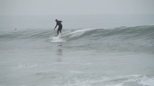 Middle aged surfer riding a powerful wave at a sunny beach on vacation