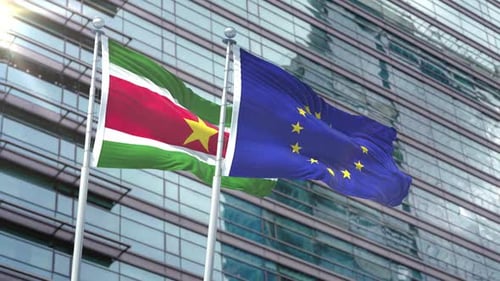 Suriname and European Union Flags Waving Against Modern Building