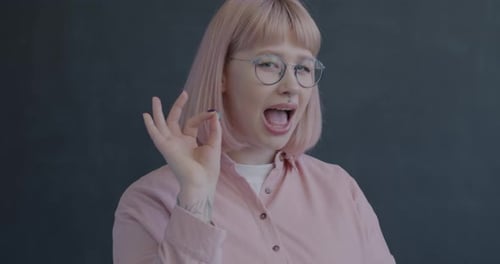 Young Woman Smiling and Making an OK Sign