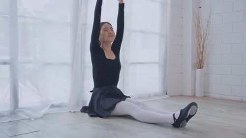 Young Woman Stretches in Ballet Attire