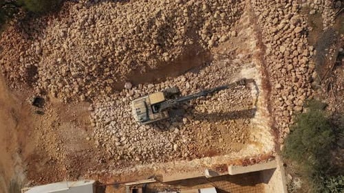 Drone Overhead View From Above of Hydraulic Arm Rock Breaking Working on Construction Site