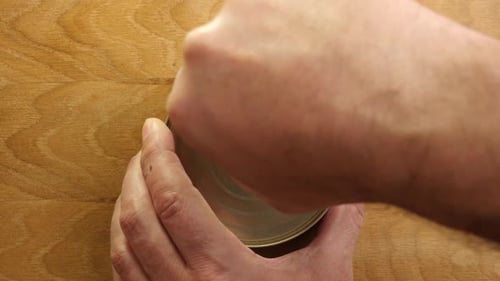 Opening Metal Can on Wooden Background